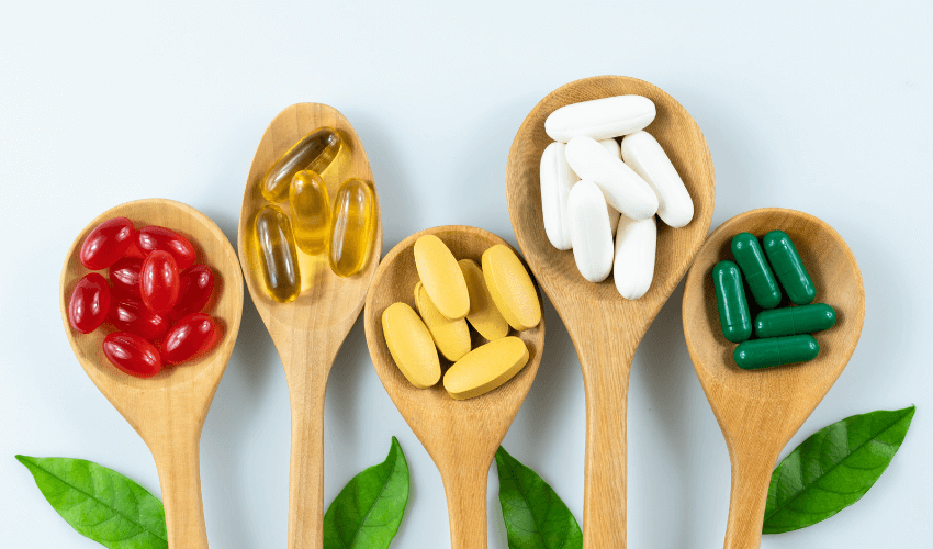 Supplements and vitamins on wooden spoons